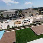 גינה עם דק עץ ירוק ושילוב