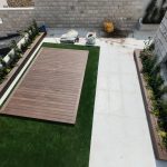 חצר עם דשא סינתטי, פרחים ועבודה