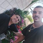 שני גננים עובדים בגינה מלאת פרחים