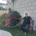 גנן יושב ליד ערוגת פרחים צבעוניים