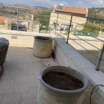 שני עציצים ריקים במרפסת עם נוף