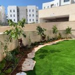 גינה מטופחת עם דשא סינתטי ועצים