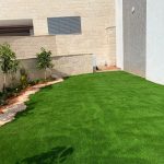הגינה עם דשא סינטטי ועצים מטופחים