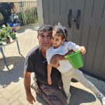 גבר עם ילדה מחזיקים עציץ ירוק