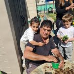 ילדים ופעיל מגונן ששותלים צמחים יחד