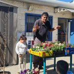 גבר מסביר לילדים על פרחים בסדנת