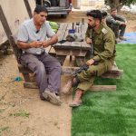 שני גברים יושבים ליד שולחן גינה,