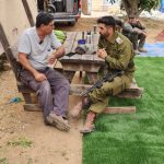 אדם וחייל יושבים ומדברים ליד שולחן