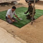 שני אנשים עובדים על התקנת דשא