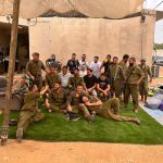 חיילים במדים יושבים וצוחקים יחד באזור