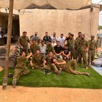 חיילים יושבים בחצר על שטיח דשא