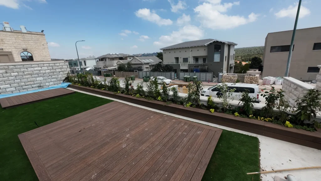 משטח דק ודשא סינטטי ולאורכם ערוגה שתולה