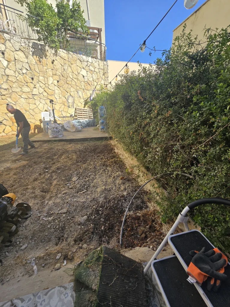 רצועת אדמה מתוחחת לאורך הגדר החיה לפני הנחת הדשא