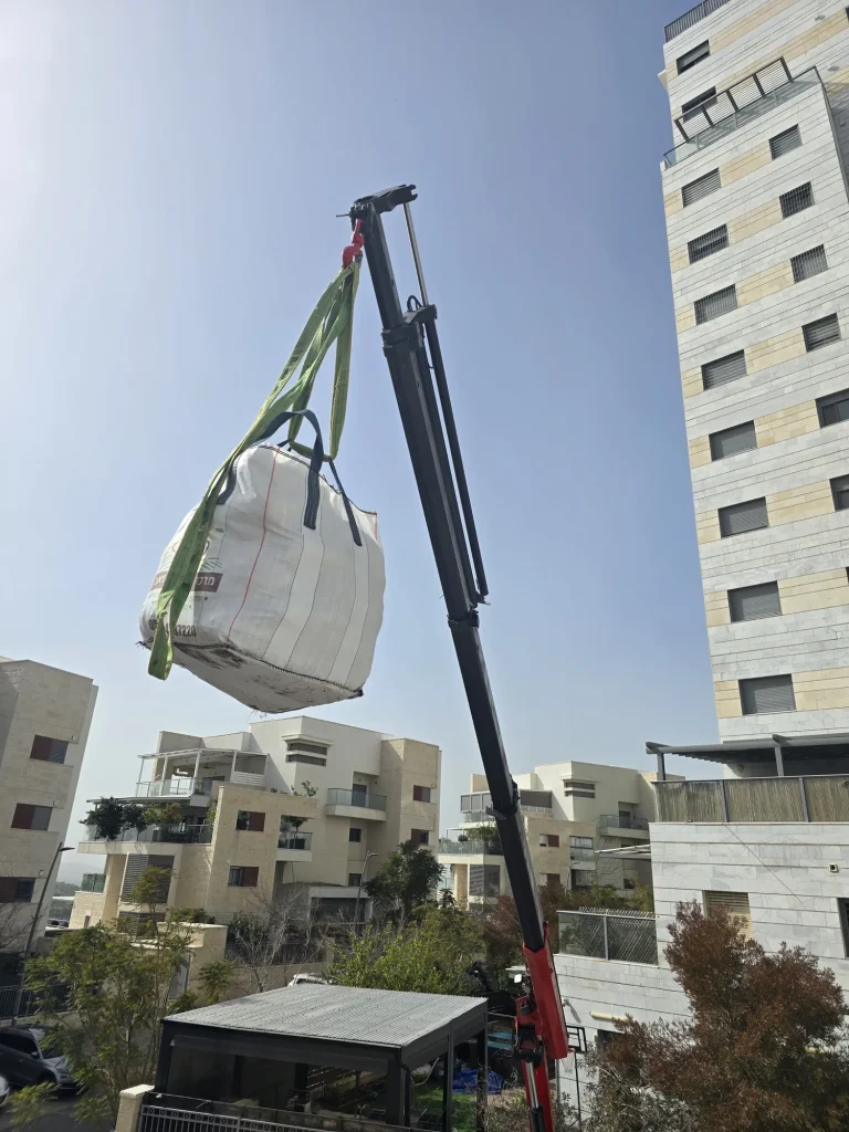 שק חומרים מונף במנוף אל קומת המרפסת