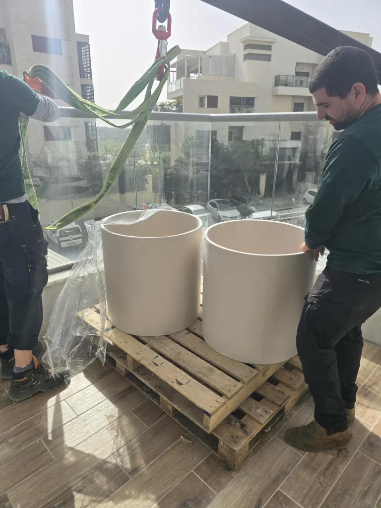 אדניות עגולות על משטח עץ לאחר ההנפה למרפסת