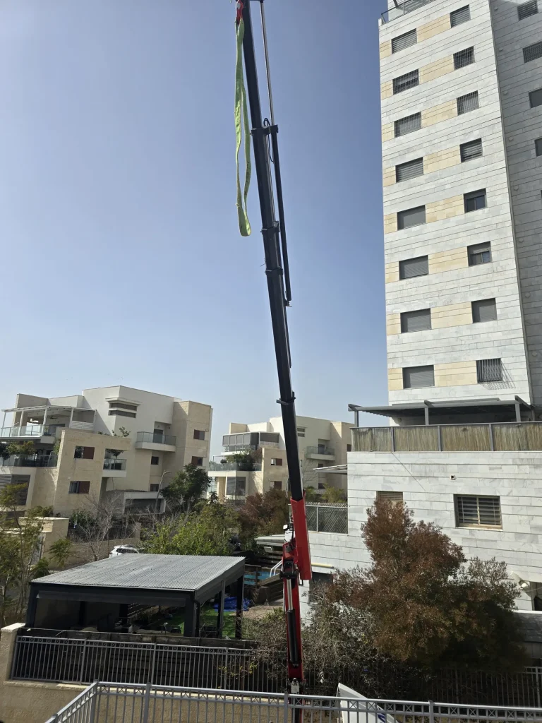 זרוע מנוף מול הבניין במהלך העלאת החומרים