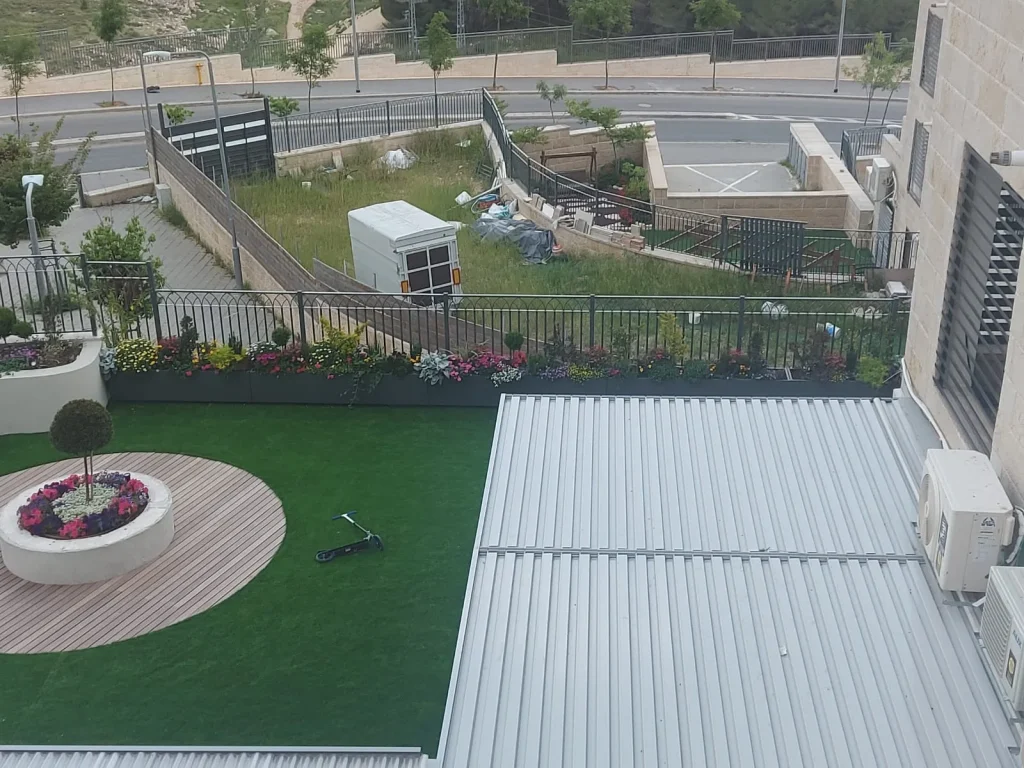 מבט מלמעלה על דק העץ העגול, האדנית המרכזית והדשא הסינטטי